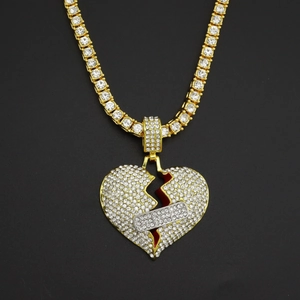 Dettaglio del ciondolo hip hop a cuore spezzato con cerotto intarsiato e strass brillanti