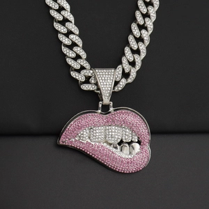 Detail van roze kristallen lippen hanger aan een zilveren Cubaanse schakelketting