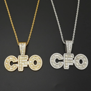 Detalle de colgantes de letras CFO en oro y plata con cristales y cadenas de cuerda