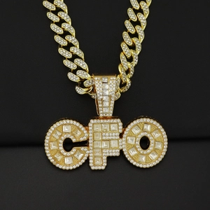Primer plano del colgante CFO dorado con circonitas incrustadas en una cadena cubana gruesa