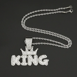 Dettaglio del ciondolo KING con corona, strass ghiacciati e catena a corda argento