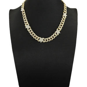 Detailed macro view of gold-plated Cuban link necklace with iced out star pendants