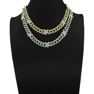Detail of gold and silver hip hop iced-out cuban link necklace with star charms