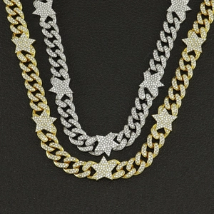 Macro shot of gold and silver hip hop Cuban link necklaces with iced out star pendants