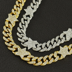 Close-up of gold and silver hip hop cuban necklaces with iced out stars on black leather
