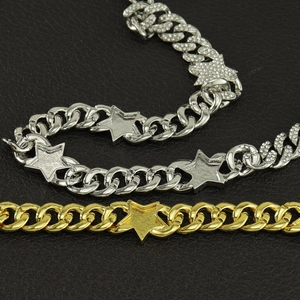 Macro view of gold and silver cuban chain with rhinestone star charms on black leather