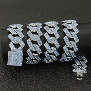 Vue macro d'un collier à maillons cubains argentés avec strass bleu clair sur socle noir