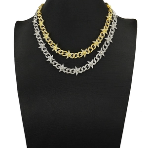 Détail de la chaîne cubaine hip hop avec pendentifs étoiles en strass, doré et argenté