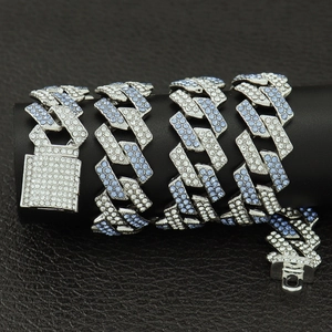 Détail macro d'une chaîne Cuban Link 15mm avec cristaux bleus et blancs sur le fermoir boîte