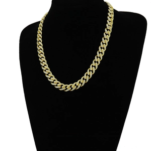 Detail of gold Cuban chain with iced-out rhinestones displayed on a black neck bust