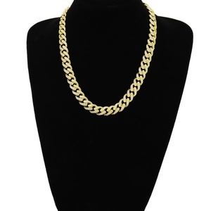 Close-up of gold plated Cuban chain necklace with white stones on a black display stand