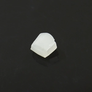Macro shot of translucent white hip-hop grillz fixing wax on black reflective surface