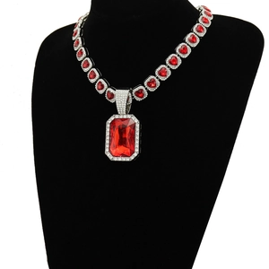 Détail d'un collier hip-hop argenté avec maillons en cœur rouge et grand pendentif en cristal