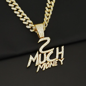 Gros plan du pendentif 2 MUCH MONEY glacé sur une chaîne cubaine dorée de luxe