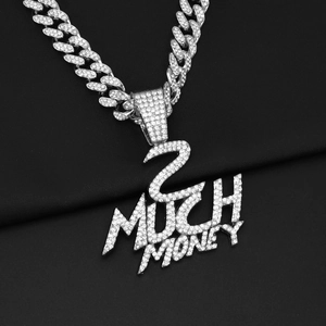Gros plan du pendentif 2 MUCH MONEY avec pierres zircons et chaîne à mailles cubaines