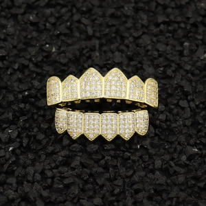 Detailed macro view of gold hip hop teeth grillz with sparkling micro paved zircon stones
