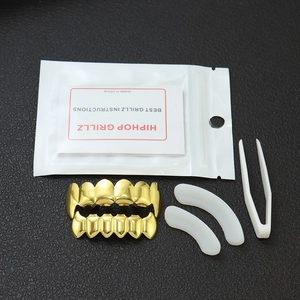 Set de grillz hip hop dorés avec barres de silicone et pince sur fond noir élégant