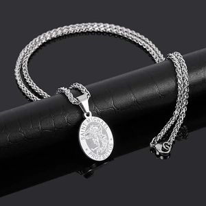 Détail du pendentif pièce Saint Michel en argent avec chaîne blé sur support noir