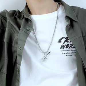 Detailed view of silver guitar pendant necklace on male model with olive green shirt