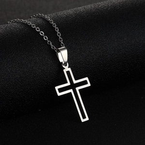 Dettaglio di un ciondolo a croce minimalista in acciaio inossidabile con inserto in smalto