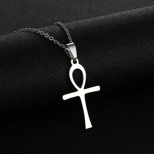 Dettaglio del ciondolo a croce Ankh in argento lucido su catena sottile e sfondo nero