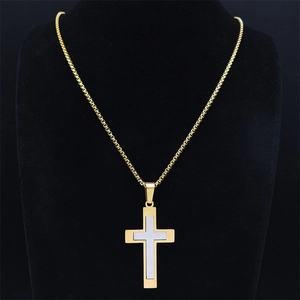 Détail du collier pendentif croix bicolore or et argent sur un mannequin de cou noir