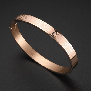 Detailed macro view of rose gold stainless steel bangle with engraved Roman numerals