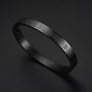 Close-up of black matte stainless steel cuff bracelet with Roman numeral engravings