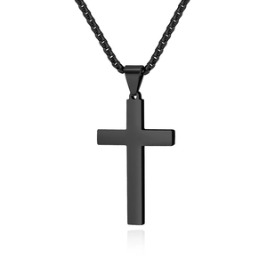 Macro detail of a minimalist matte black cross pendant with a matching box chain