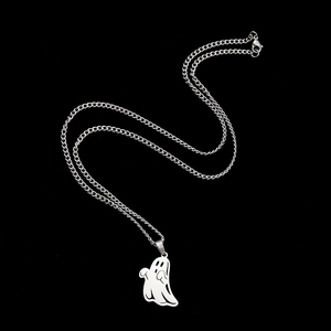 Detailed view of silver ghost pendant necklace with polished finish on black background