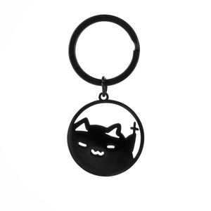 Detail of matte black stainless steel hollow cat keychain with cross symbol silhouette