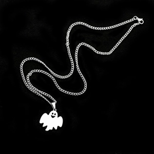 Detailed view of silver ghost pendant with cutout smiley face on stainless steel Cuban chain