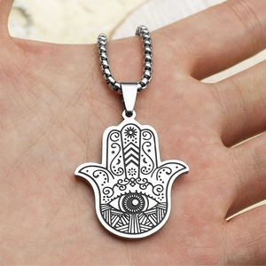 Détail du pendentif Main de Fatma avec symbole de l'œil gravé tenu dans la paume