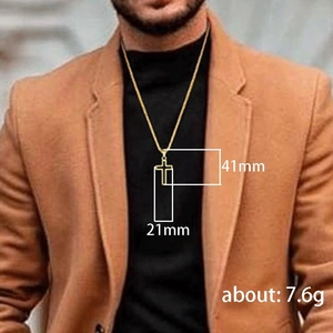 Detail shot showing 41mm by 21mm gold cross pendant dimensions on a male model