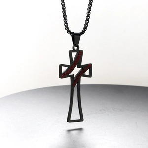 Close-up of black stainless steel cross pendant with red baseball stitching and lightning cutout