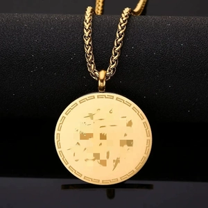 Collana con ciondolo dorato rotondo con incisione artistica e catena a spiga su nero