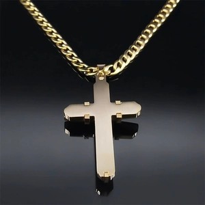 Macro shot of polished gold stainless steel cross pendant with thick curb chain link