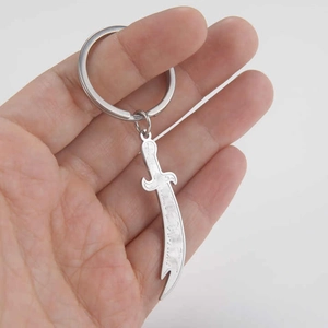 Close-up of a silver stainless steel scimitar sword keychain with brushed metal finish
