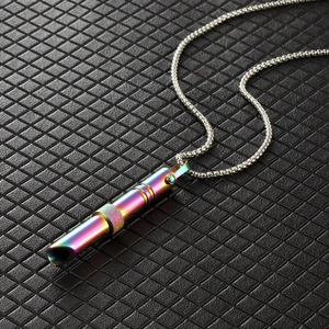 Detail of colorful rainbow meditation whistle pendant with gold ring on silver chain