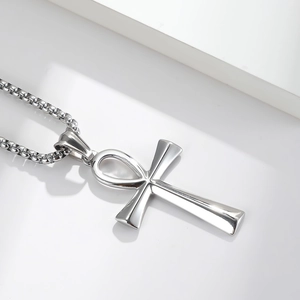 Polished silver stainless steel Ankh cross pendant necklace with box chain on grey podium