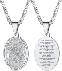 Close-up of Saint Michael silver pendant showing detailed relief and prayer text engravings