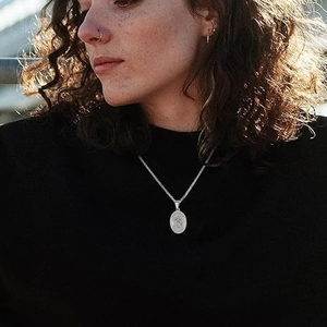 Archangel Saint Michael silver medallion pendant worn by model in warm sunlight