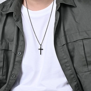 Minimalistische schwarze Edelstahl Kreuzkette am männlichen Modell mit dunklem Urban-Style