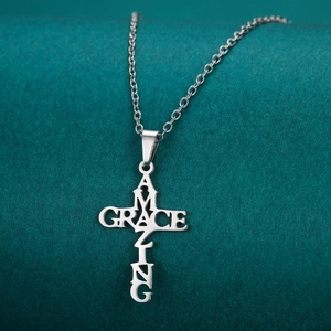 Detailed macro view of silver stainless steel cross pendant with Amazing Grace cutout