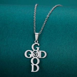 Close-up of stainless steel cross pendant featuring GOD and GOOD letter engraving