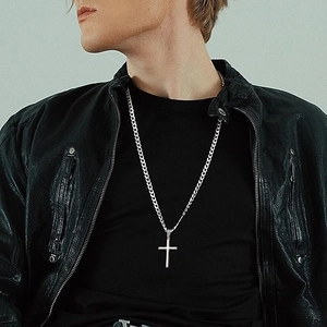 Polished silver stainless steel cross necklace on male model wearing a black leather jacket
