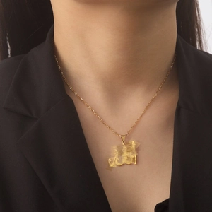 Collier en acier inoxydable doré avec pendentif calligraphie arabe porté par un mannequin