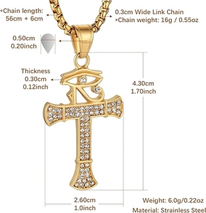 Détail du collier croix en acier doré avec l'œil d'Horus et des cristaux