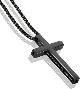 Detalle macro del collar de cruz en acero inoxidable negro con grabado religioso