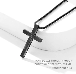 Gros plan du pendentif croix en acier noir mat avec gravure laser de Philippiens 4:13